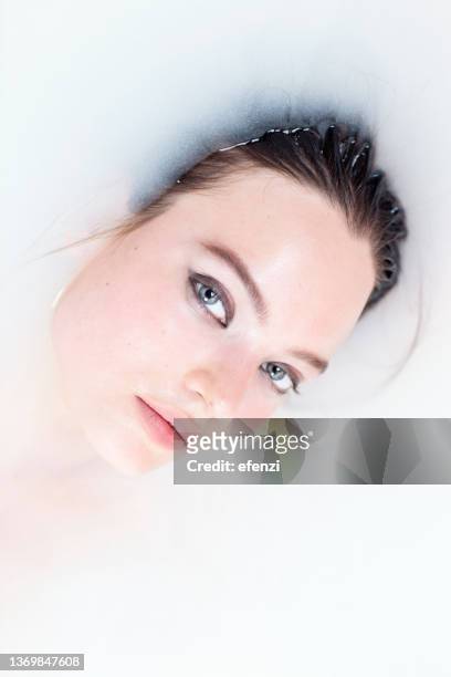 porträt einer frau in einem milchbad - milchbad stock-fotos und bilder