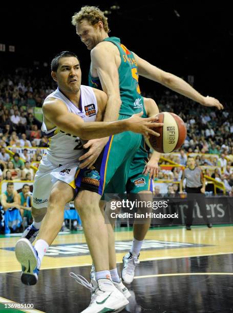 Luke Martin of the Kings passes the ball around Luke Schenscher of the Crocodiles during the round 15 NBL match between the Townsville Crocodiles and...