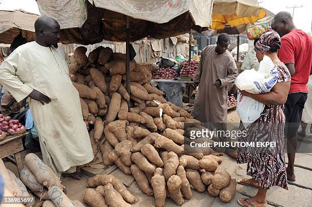 Woman tries to buy yam but vendor complains of low patronage because of hike in pump price that has affected cost of food stuff at Mile 12 market in...
