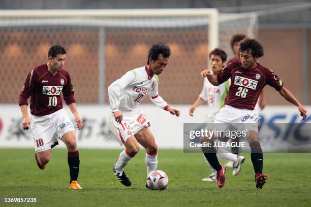 Toshiya Fujita of Nagoya Grampus competes for the ball against Raphael Botti and Ryosuke Matsuoka of Vissel Kobe during the J.League Yamazaki Nabisco...