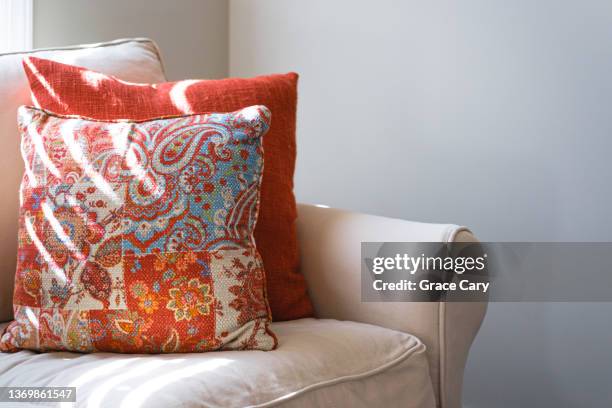 corner of sofa with accent pillows and sunlight - cushion stockfoto's en -beelden