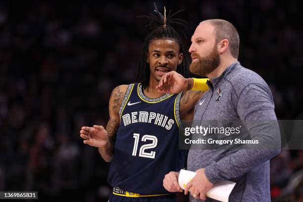 Ja Morant of the Memphis Grizzlies talks with head coach Taylor Jenkins while playing the Detroit Pistons at Little Caesars Arena on February 10,...