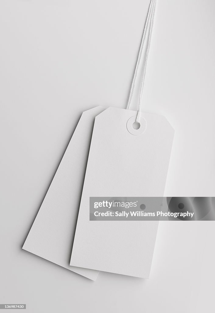 Two white luggage tags