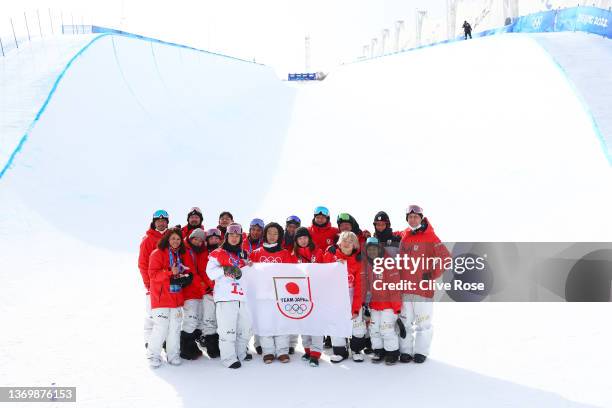 Gold medallist Ayumu Hirano of Team Japan poses for a photo with members of Team Japan after the Men's Snowboard Halfpipe flower ceremony on day 7 of...