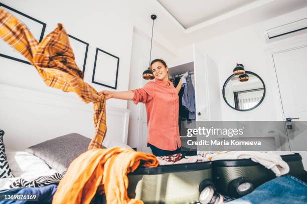 happy woman packing suitcase in bedroom. - project traveller stock pictures, royalty-free photos & images