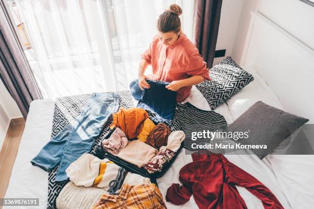 happy woman packing suitcase in bedroom. - unpacking stock pictures, royalty-free photos & images