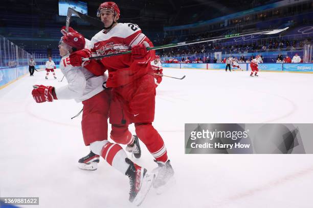 Oliver Lauridsen of Team Denmark checks Pavel Karnaukhov of Team ROC near the corner boards in the second period during the Men's Ice Hockey...