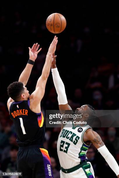 Devin Booker of the Phoenix Suns shoots over Wesley Matthews of the Milwaukee Bucks during the second half at Footprint Center on February 10, 2022...