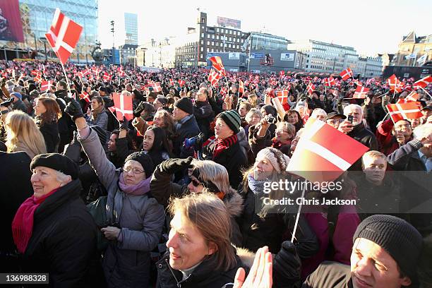 Members of the public wave Danish flags as Queen Margrethe II of Denmark waves from the balcony of City Hall after the official reception to...