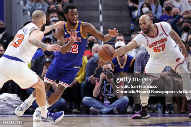 Golden State Warriors' Andrew Wiggins vies for loose ball against New York Knicks' Evan Fournier and Taj Gibson during Knicks' 116-114 win in NBA...