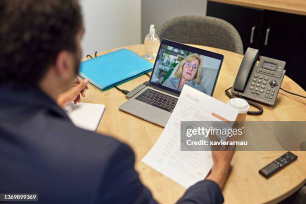 human resources manager interviewing mature job applicant - 50s woman writing at table imagens e fotografias de stock