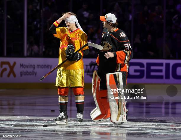 John Gibson of the Anaheim Ducks looks on after putting a blindfold on his teammate Trevor Zegras, who dressed as Peter La Fleur from the movie...