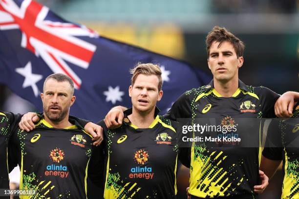 Matthew Wade, Steve Smith and Pat Cummins of Australia sing the national anthem before play in game one in the T20 International series between...