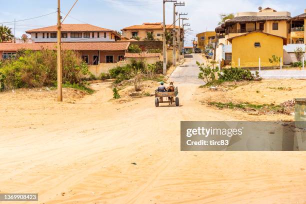 caballo y carro a la antigua usanza que ingresa al pueblo de canoa quebrada - horsedrawn fotografías e imágenes de stock