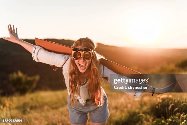 happy woman pretending to be an airplane in nature at sunset. - pretending to be a plane stockfoto's en -beelden