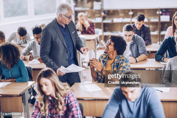 heureux étudiant noir parlant à un professeur dans la salle de classe. - assistant professor photos et images de collection