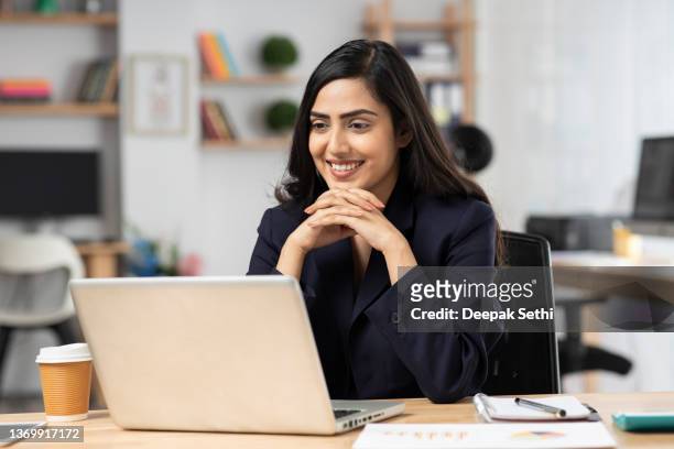 junge frau im büro, die am laptop arbeitet. stockfoto - indian woman stock-fotos und bilder