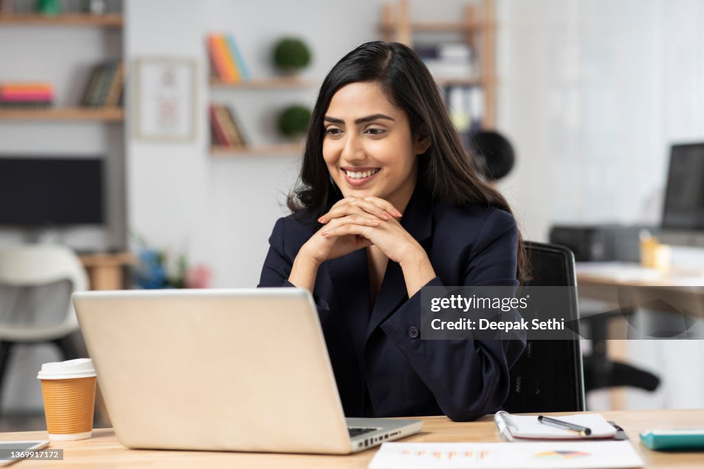 Young woman in office working on laptop. stock photo