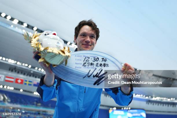 Gold medallist Nils van der Poel of Team Sweden celebrates with a board showing the time after setting a new World Record time of 12:30.74 during the...