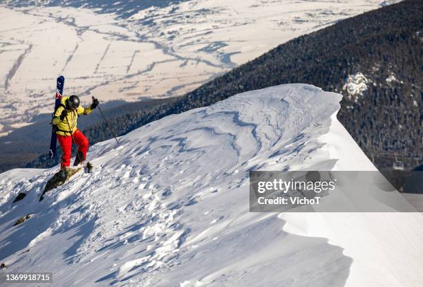 esquiador freeride escalando una cresta de montaña sobre la zona de la estación de esquí - zona de confort fotografías e imágenes de stock