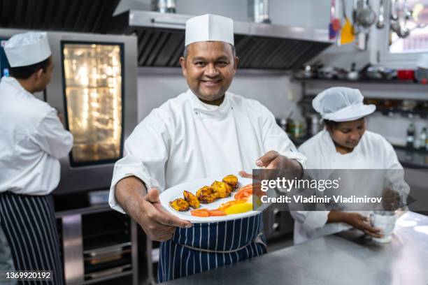 chefkoch präsentiert einen teller mit speisen - indian cuisine stock-fotos und bilder