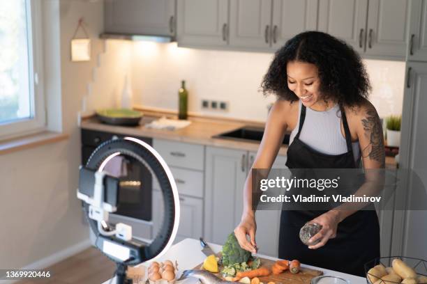 ein influencer, der gesundes essen und kochen vloggt - cooking on camera stock-fotos und bilder