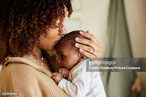 mother kissing with her baby boy in her arms - bebê imagens e fotografias de stock