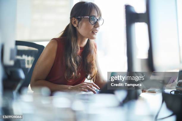 una mujer de negocios está mirando de cerca la pantalla de la computadora. - argentina women fotografías e imágenes de stock