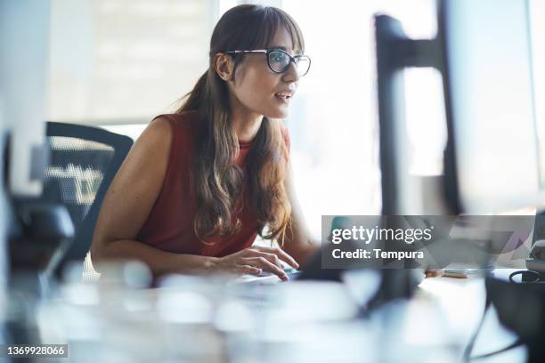 a businesswoman is looking closely at the computer screen. - argentinian people stock pictures, royalty-free photos & images