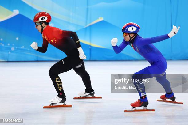 Dajing Wu of Team China and Pietro Sighel of Team Italy compete during the Men's 500m Heats on day seven of the Beijing 2022 Winter Olympic Games at...