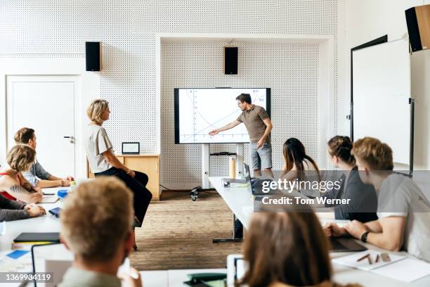 student giving presentation during seminar session - corso di formazione foto e immagini stock