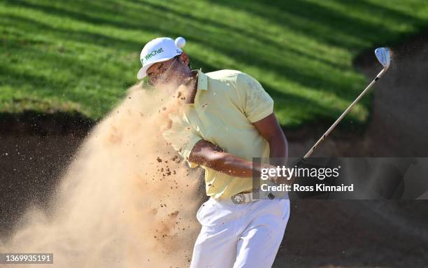 Haotong Li of China hits a bunker shot on the 14th hole during day two of the Ras Al Khaimah Classic at Al Hamra Golf Club on February 11, 2022 in...