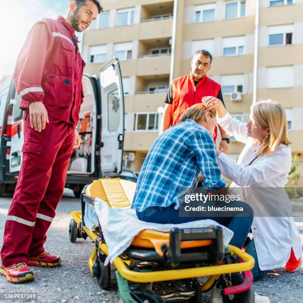 medical emergency team helping injured woman - emergency first response stock pictures, royalty-free photos & images