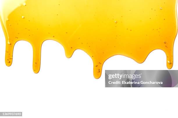 drops of sweet yellow honey on a white isolated background - fruchtzucker stock-fotos und bilder