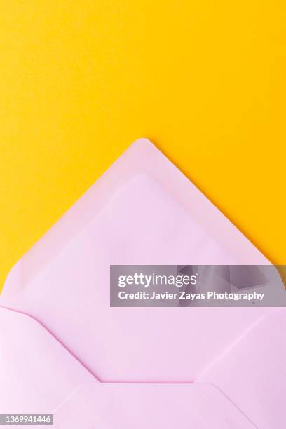 open pink envelope on a yellow background - pink envelope stockfoto's en -beelden