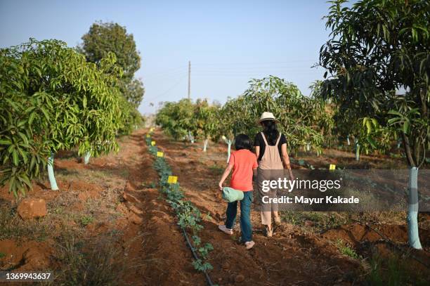 rear view of mother and daughter walking in the farm - sustainable business stock pictures, royalty-free photos & images