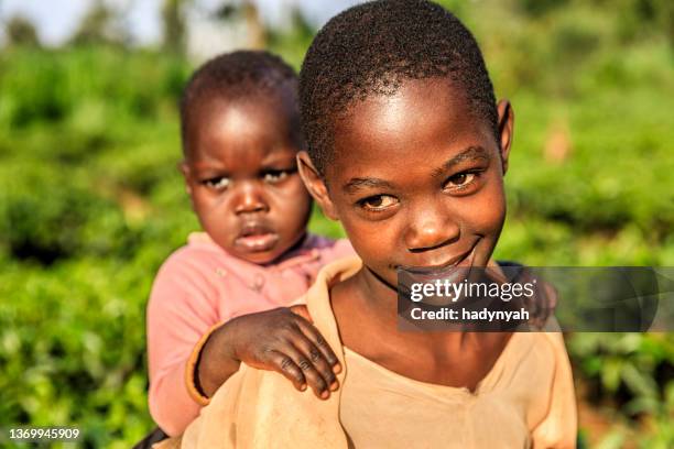 kleine afrikanische mädchen hält ihren kleinen bruder, kenia, ostafrika - afrikanischer volksstamm stock-fotos und bilder