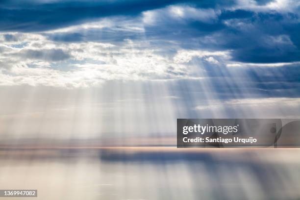 sunbeams over the atlantic ocean - horizon over land stock-fotos und bilder