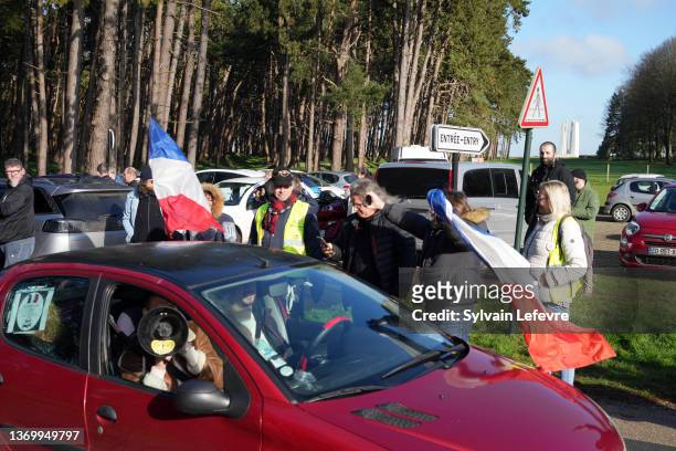 Supporters wave French national flags and cheer French anti-COVID restrictions car drivers at the foot of the Canadian National Memorial in Vimy...