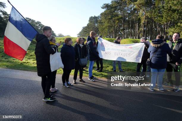 Supporter hold a French national flags and banner reading "we are not your guinea pigs, neither the adults nor the children" as they attend French...