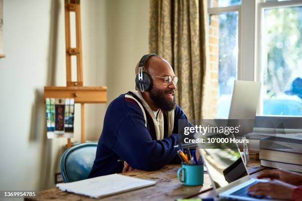 businessman on video conference in home office - mann am computer stock-fotos und bilder