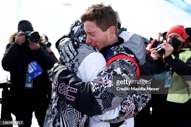 Shaun White of Team United States embraces their coach JJ Thomas after finishing fourth during the Men's Snowboard Halfpipe Final on day 7 of the...
