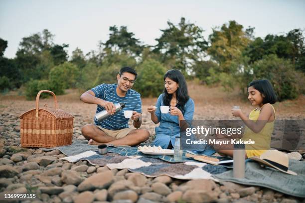 family enjoying food during outdoor picnic in nature - indian family vacation stock pictures, royalty-free photos & images