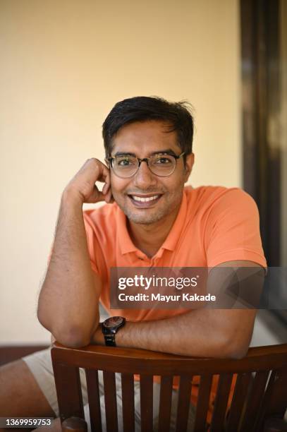 portrait of a man sitting on a chair outside his house - colors of india photos et images de collection