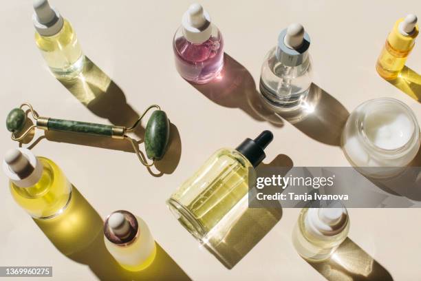 glass bottles for cosmetic products with pipette, natural skincare face cream and essential oil on beige background. beauty products. multitasking beauty, skinmalism, skin care concept. - skin care products stock pictures, royalty-free photos & images