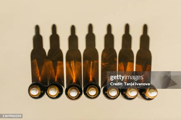 glass bottles for cosmetic products with pipette, natural skincare and essential oil on beige background. beauty products. multitasking beauty, skinmalism, skin care concept. - jojoba stockfoto's en -beelden