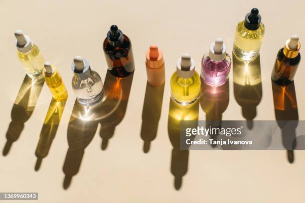 Glass bottles for cosmetic products with pipette, natural skincare and essential oil on beige background. Beauty products. Multitasking beauty, skinmalism, Skin care concept.
