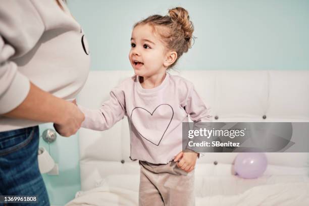 little girl looks at her mother's belly - little kids belly imagens e fotografias de stock