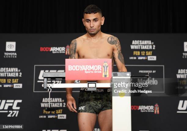 Alex Perez poses on the scale during the UFC 271 official weigh-in at the Westin Oaks hotel on February 11, 2022 in Houston, Texas.