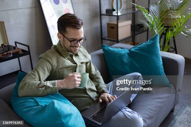 high angle close up view of a young caucasian man using a laptop at home - laptop high up stock pictures, royalty-free photos & images